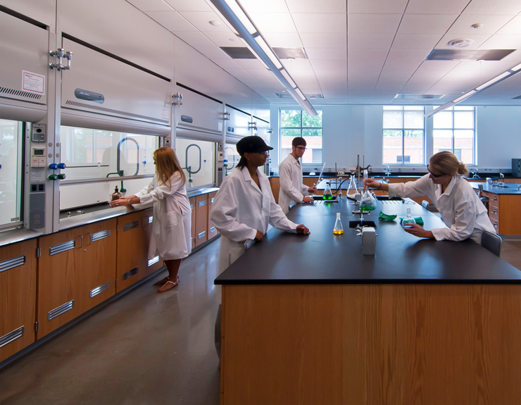 Students hover over a central lab table